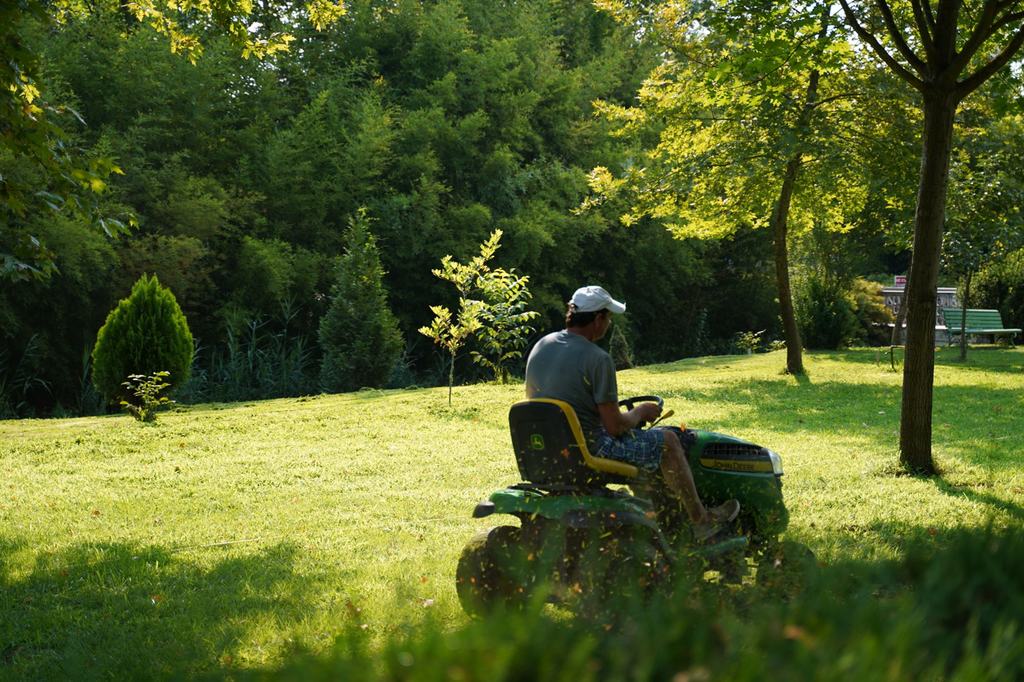 A gardener cutting a large lawn on a ride-on mower